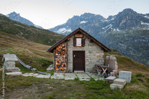 Lone cabin with wood pile above Realp, Uri, Switzerland photo