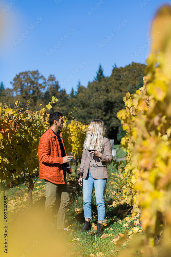 A couple enjoys a walk through a vineyard in Oregon. A couple enjoys a walk through a vineyard in Oregon.