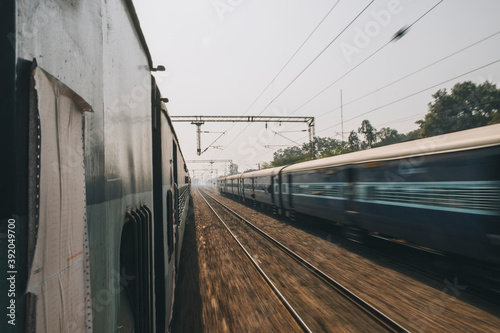 Ordinary express train on a trip from New Delhi to Agra just passing by another train the opposite direction.