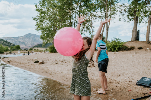 Young girl getting hit in the face with a large ball on a summer day