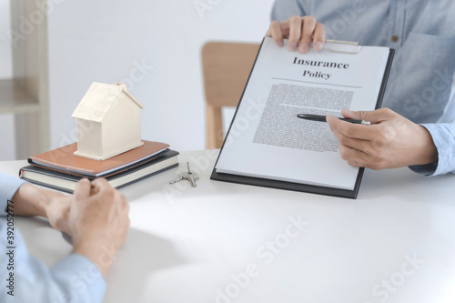 Real estate agent meeting customer with insurance policy about house contract.