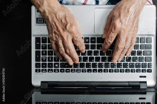 elderly person working on laptop