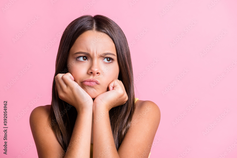 Portrait of upset little girl ignore look empty space hands cheekbones isolated on pink color background Portrait of upset little girl ignore look empty space hands cheekbones isolated on pink color background