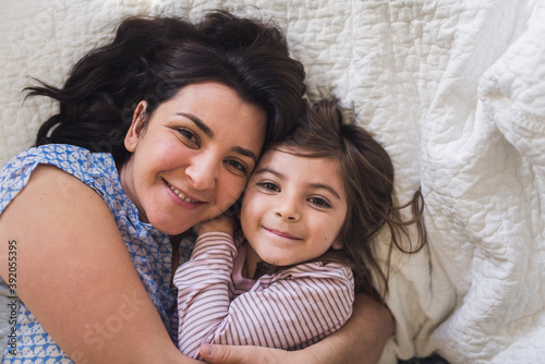 Snuggle time for happy mid-30's mom and 6 yr old daughter photo