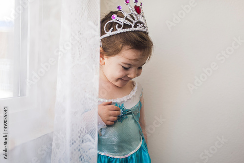 Smiling 4 yr old girl dressed in blue princess gown and crown photo