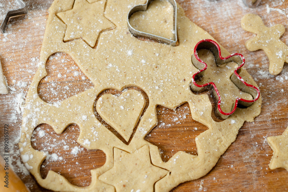 Still life, a top view of the kitchen board with a dough for gingerbread with already cut shapes. Still life, a top view of the kitchen board with a dough for gingerbread with already cut shapes.