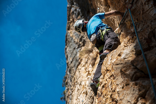 Climber in the right side and the blue sky in the left photo