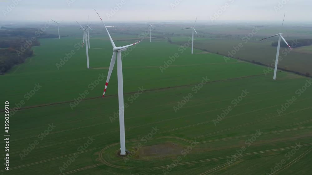Aerial view of windmills farm for energy production on farmlands at countryside. The windmills are not spinning and the weather is autumn, gray sad sky. Aerial view of windmills farm for energy production on farmlands at countryside. The windmills are not spinning and the weather is autumn, gray sad sky.