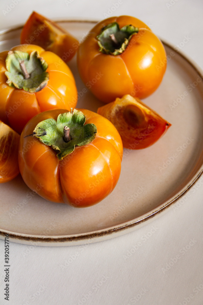 Fresh bright orange autumn persimmon on white background Fresh bright orange autumn persimmon on white background