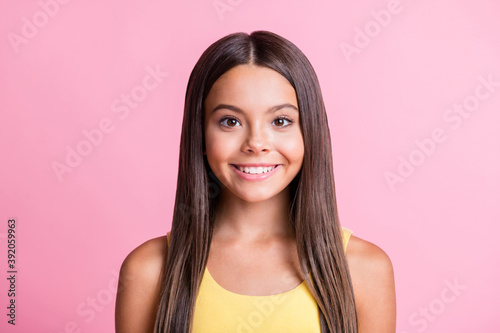 Photo portrait of smiling girl isolated on pastel pink colored background
