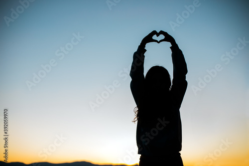 Hands form a Heart for Love Silhouette with Sunset or Sunrise