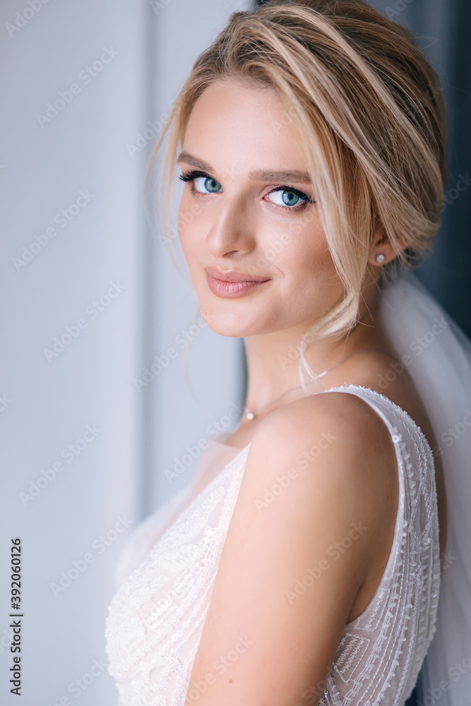 a bride with beautiful makeup with blue eyes and a sweep to smile looks at the camera. a bride with beautiful makeup with blue eyes and a sweep to smile looks at the camera.