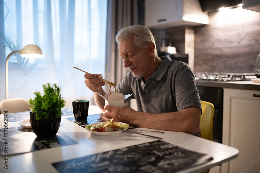 Senior man eating delivery food Senior man eating delivery food