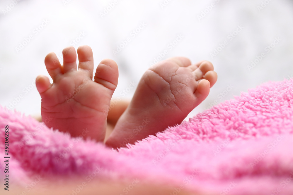 Infant's small feet closeup on a blanket
