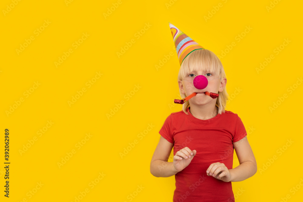 Boy in party hat, clown nose, and whistle. Childrens holiday party. Boy in party hat, clown nose, and whistle. Childrens holiday party.