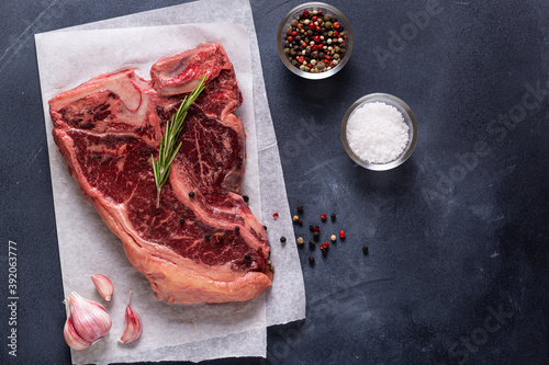 Fresh raw t-bone steak on dark background