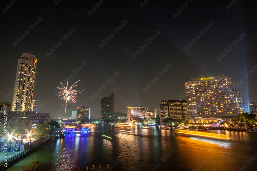 Fototapeta premium fireworks, Take photos of the night view of the city on New Year's Day with fireworks from a boat in the middle of the river