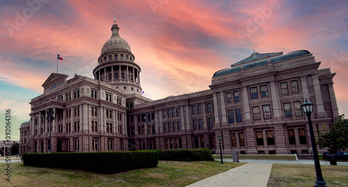 View of the Texas State Capitol building with domed roof made of Sunset Red Granite stone at dusk with pink and orange colored sky photo