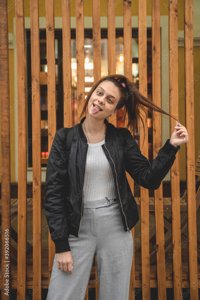 Fototapeta premium A young woman with a high ponytail is standing and fooling around