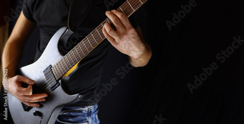 musician plays electric guitar, concept of rock, metal music on black background