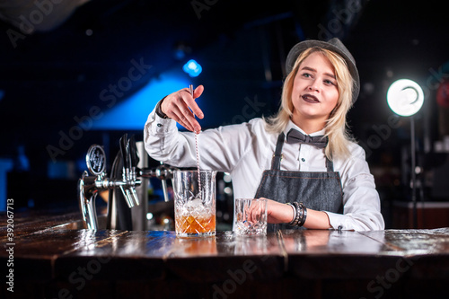 Girl barman formulates a cocktail in the beerhall photo