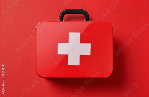 First aid kit on red background photo