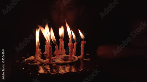 Happy child looks at a cake with candles. Happiness concept