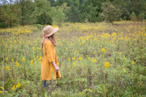 Young Girl in Yellow Dress in a Field of Flowers photo