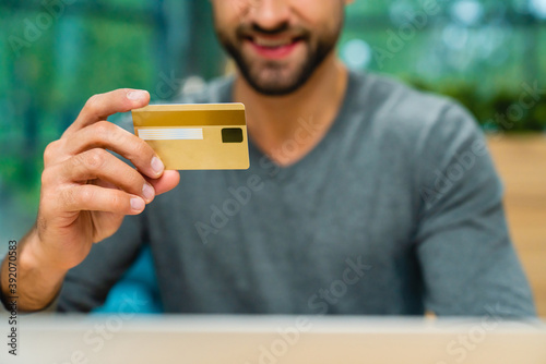 Selective focuse shot of credit card with smiling man in the background photo