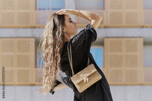 Portrait of curly blonde hair young woman with a brown handbag photo