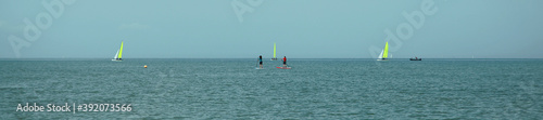 Voiliers et paddle en bord de mer
