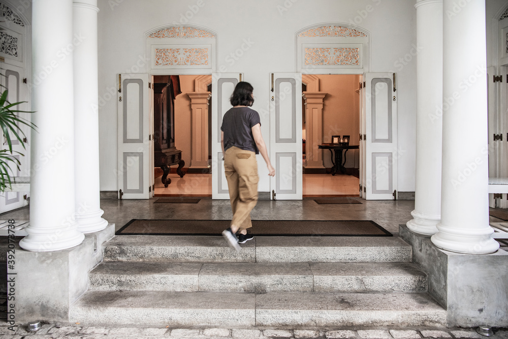 woman walking into manour house style boutique hotel in Colombo woman walking into manour house style boutique hotel in Colombo