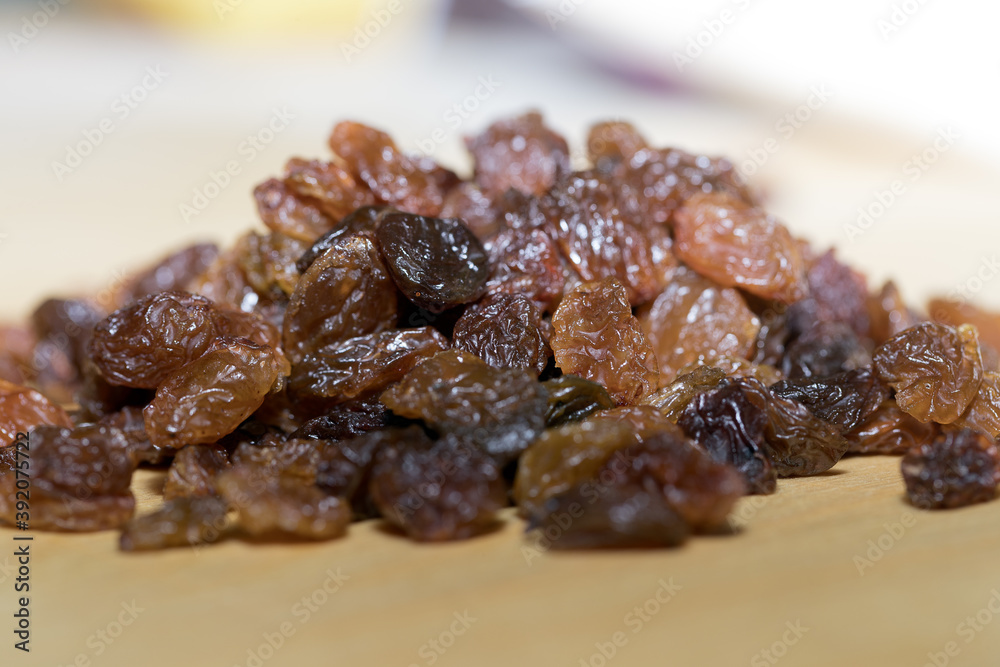 handful of raisins, raisins on a cutting board handful of raisins, raisins on a cutting board