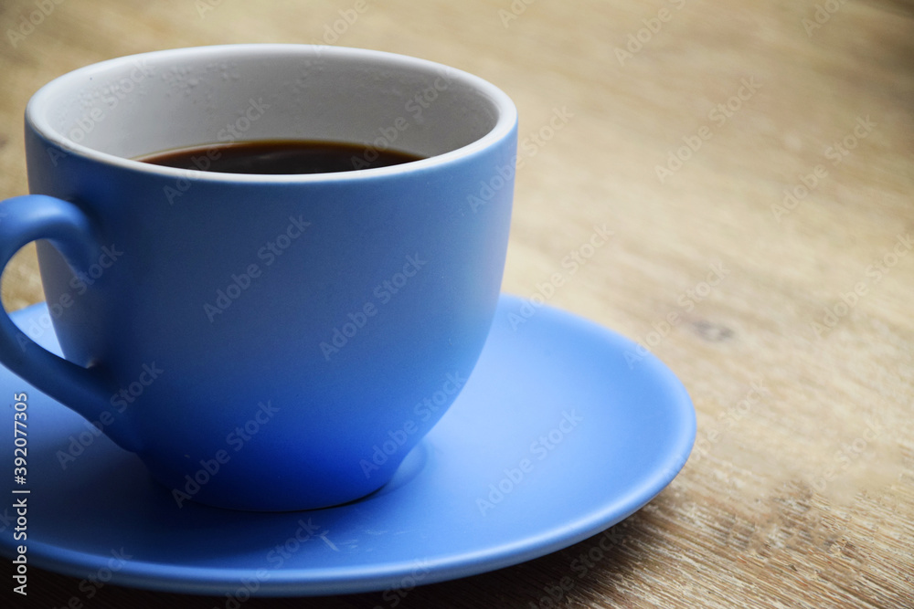Coffee time with large blue cup with black coffee on wooden table. Coffee time with large blue cup with black coffee on wooden table.