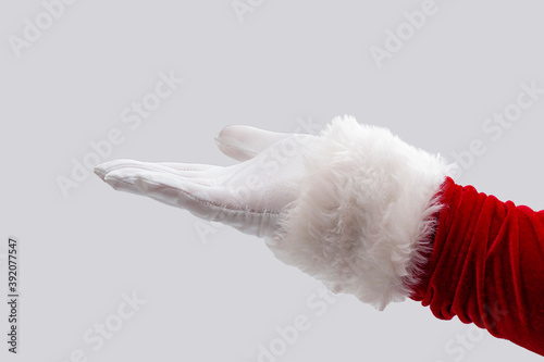 Merry Christmas, the season of giving and Happy Holidays concept with Santa Claus hand stretched out in open palm gesture isolated on white background with clipping path cutout photo