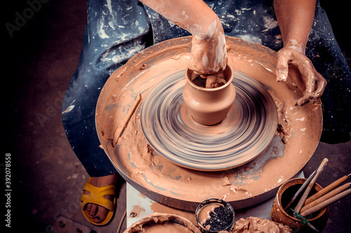 hands of potter do a clay pot photo