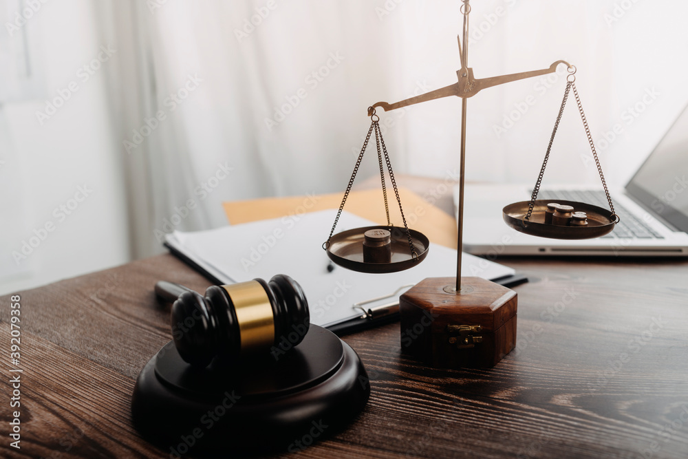 Business and lawyers discussing contract papers with brass scale on desk in office. Law, legal services, advice, justice and law concept picture with film grain effect Business and lawyers discussing contract papers with brass scale on desk in office. Law, legal services, advice, justice and law concept picture with film grain effect