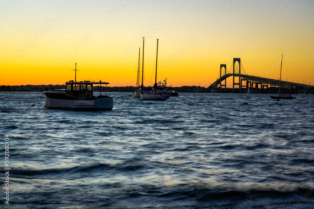 Boats near Pell Bridge in Newport at sunset.