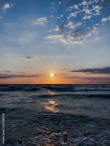 Beautiful sunrise on the beach, calm and quiet, with sun and clouds at the beginning of the day. © kellyna