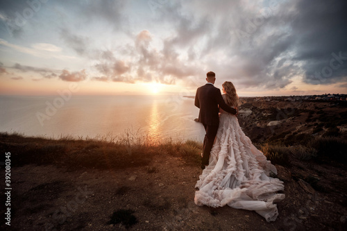 portrait of a happy bride in luxury dress and groom, wedding at sunset