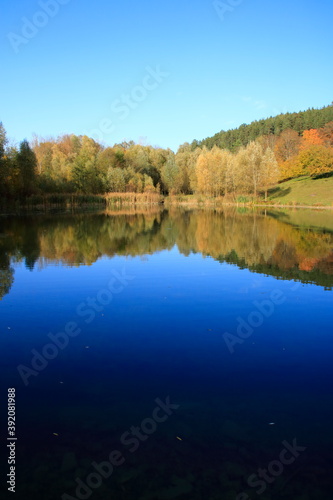 Blick auf den G  ltlinger See. Der Herbstwald spiegelt sich im See.