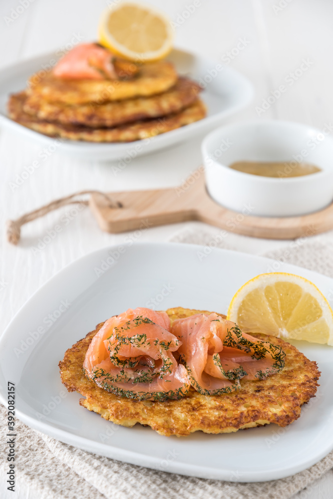 Potato pancake with salmon, lemon and mustard dip on white background, vertical stock photo Potato pancake with salmon, lemon and mustard dip on white background, vertical stock photo