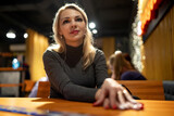 Portrait of a young blonde girl in a cafe in the evening.