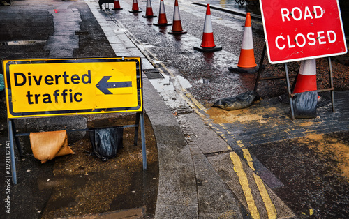 Obraz na plátně Road closed and Diverted traffic signs on wet asphalt road, orange blocking cone