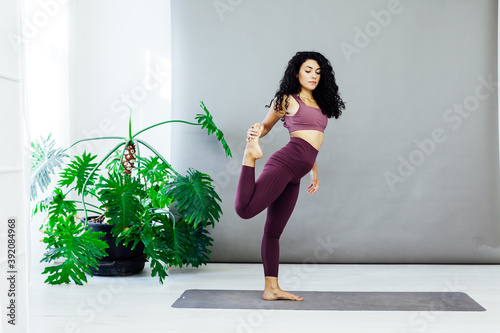 Beautiful woman yoga gymnastics flexible stretching asana fitness white room photo