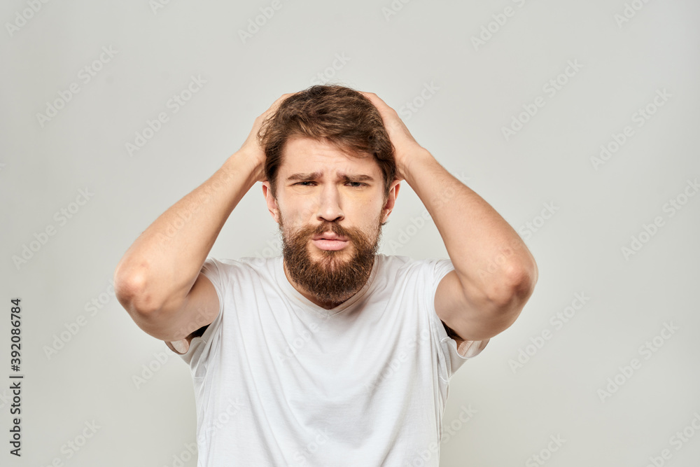 man in white t-shirt gesturing with his hands studio dissatisfaction lifestyle light background man in white t-shirt gesturing with his hands studio dissatisfaction lifestyle light background
