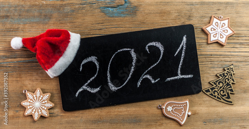 2021 - chalkboard with outlined text with red Santa hat - on wood wall