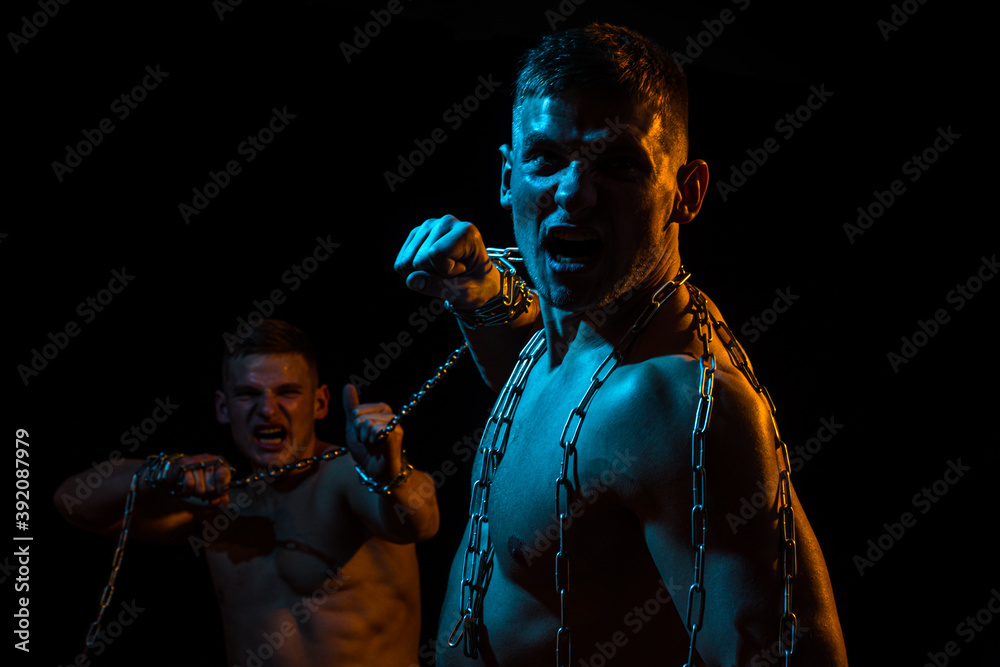 Man battle. Chest muscles. Male torso. Men with broken chains, holding chain. Muscular guys.