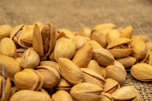 Salted pistachios lie on the burlap. Close up.