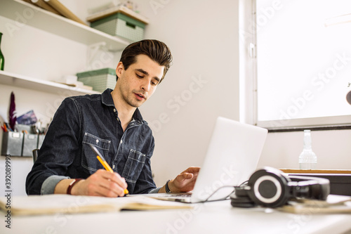 Man taking notes in home office